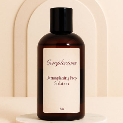 Luxury amber bottle of Complexions Dermaplaning Prep Solution displayed on a beige marble spa surface with soft lighting, professional skincare packaging for estheticians