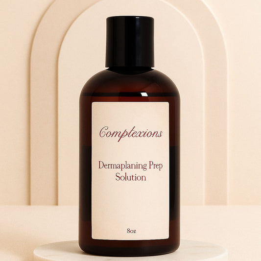 Luxury amber bottle of Complexions Dermaplaning Prep Solution displayed on a beige marble spa surface with soft lighting, professional skincare packaging for estheticians