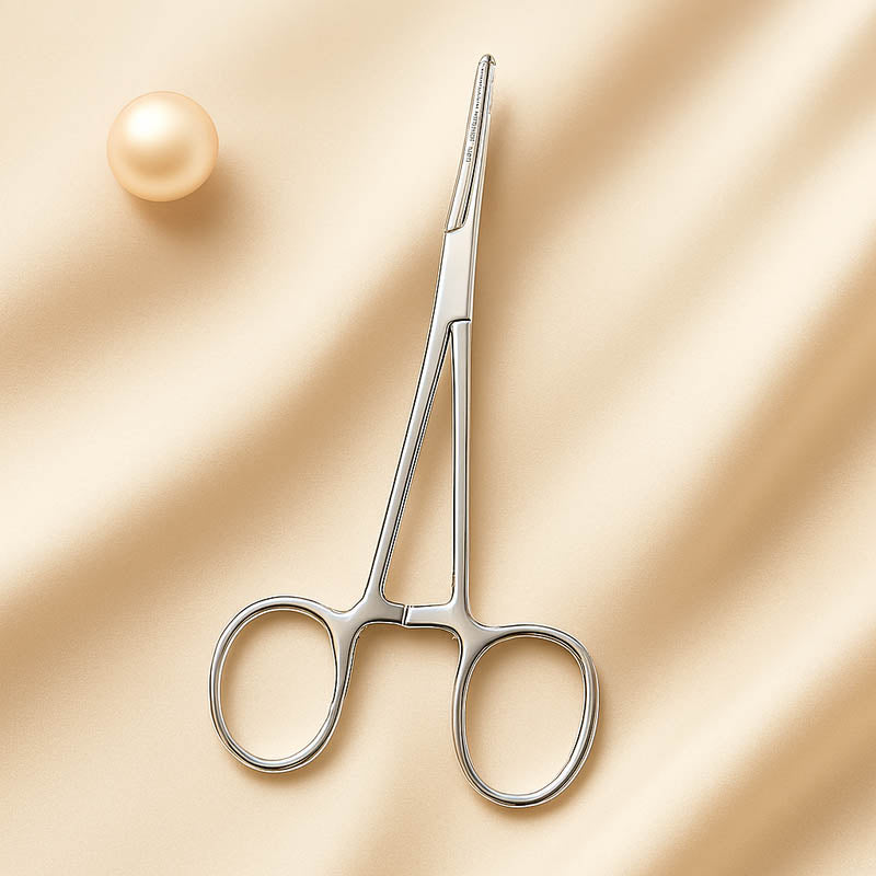 Close-up of stainless steel hemostatic forceps used by estheticians for precision dermaplaning and skincare treatments, displayed on a clean neutral background for a professional, medical-grade aesthetic