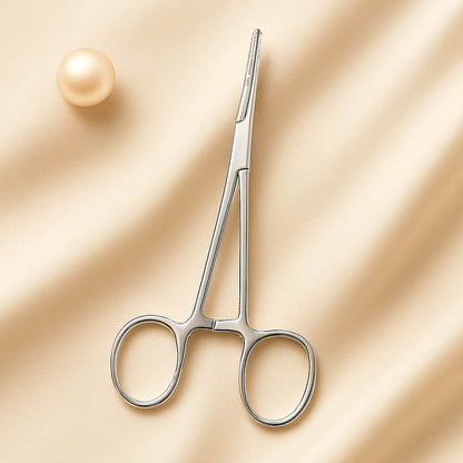Close-up of stainless steel hemostatic forceps used by estheticians for precision dermaplaning and skincare treatments, displayed on a clean neutral background for a professional, medical-grade aesthetic