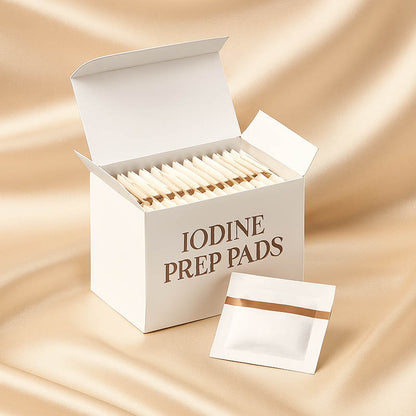 Close-up of a box of 100 iodine prep pads used for skincare and dermaplaning preparation, displayed in a clean spa-inspired setting with soft neutral tones to convey sanitation, safety, and professional quality